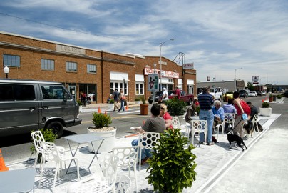 Em Wichita, estado de Kansas, o projeto estreitou uma avenida, ocupado duas pistas com ciclovia, um café ao ar livre, calçadas mais largas, floreiras e bancos. Foto de Ty Nigh/ Flickr