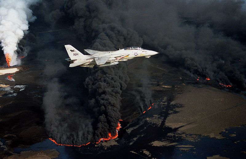 Um caça supersônico Grumman F-14A, da Marinha dos Estados Unidos, sobrevoando poços incendiados no Kuwait durante a Operação Tempestade no Deserto, durante a Guerra do Golfo (crédito: Lt. Steve Gozzo, USN - Domínio Público)